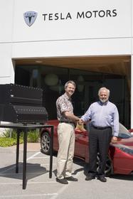 Martin Eberhard, Tesla CEO (left) and Jan-Olaf Willums,<br> Think CEO (right) with Tesla's Energy Storage System (ESS)<br> and the Tesla Roadster.