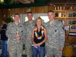 Bad Ass Coffee of Hawaii employee poses with soldiers at the company's flagship store in Utah.  The occasion was in honor of Bad Ass Coffee of Hawaii's Cup O' Joe program, a nonprofit initiative that allows customers to donate bags of coffee to soldiers overseas.

