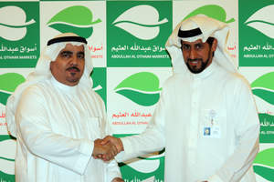 Badr Al-Badr handshaking Al-Othaim Markets Chairman, Abdulla Al-Othaim