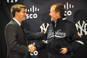 Hal Steinbrenner of the Yankees presents Cisco CEO John Chambers with a Yankees jacket at the Cisco-Yankees press conference at Cisco offices in New York, New York on November 11, 2008