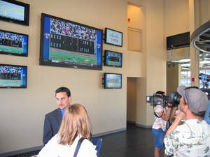 Kansas City media members and representatives from AT & T and Cisco look at the video display at Rivals Sports Bar in Kauffman Stadium, Kansas City, Missouri.  The largest television at Rivals is 103 inches wide.