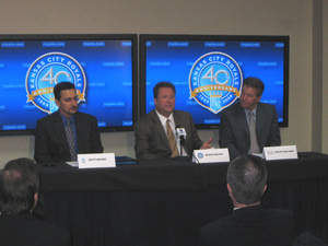 Kevin Uhlich, Senior Vice President of Business Operations for the Royals, addresses the media as Matt Moore of AT & T (left) and David Holland of Cisco Systems (right) look on.