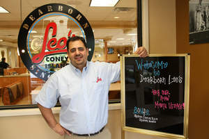 Ken Vlahadamis of Leo's Coney Island displays the restaurant's welcome sign at the new Dearborn location. 