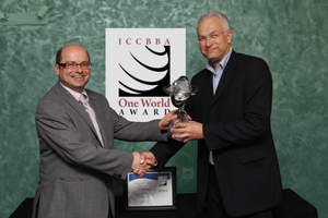 Dr. Jorgen Georgsen, Chairman of the Board of Directors of ICCBBA, presents the One World Award to Dr. Charles Munk.