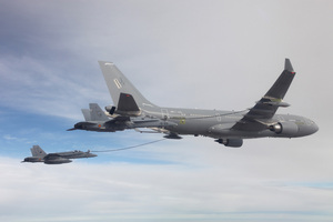 An A330 Multi-Role Tanker Transport simultaneously refuels two F/A-18 fighters via its all-digital hose-and-drogue refueling pods on each wing. 