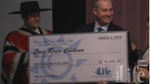 On behalf of 4Life worldwide distributors, Senior VP Marketing Trent Tenney (right) and Nelson Altamirano present $10,000 Foundation 4Life Chilean Relief Check on Azteca America Television.  
