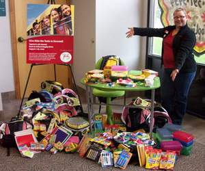 Proud TopLine employee Amy Eder with more than 400 school supply donations from TopLine employees and members.