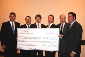 Sean Browne, President & CEO of NRG, (third from the right), receives the check in the presence of Gov. Rick Perry and Dallas Mayor Tom Libbert.