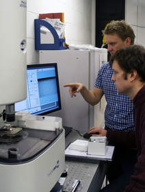 Dr. Robert Stokes (left), from NanoInk and Dr. Nicholas Laurand (right), from the Institute of Photonics at the University of Strathclyde, look at a substrate being patterned using NanoInk's NLP 2000.  The Institute of Photonics plans to use the NLP 2000 specifically for the deposition of soft materials to existing structures to generate optical effects, color conversion and for laser fabrication.  
