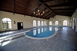 The home includes five bedrooms, a heated indoor pool, wine cellar and a commercial and private kitchen.