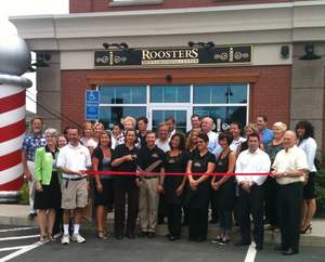 At Roosters Men's Grooming Center in Glastonbury, Conn., franchise owner Tammy Clark prepares for the store's ribbon cutting with assistance from partner and co-owner Ken Cupples, at right. 