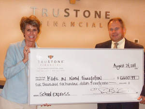 Jeanne Mock (left) from The Kids In Need Foundation accepted a donation check over $6,600 from Tim Bosiacki, CEO of TruStone Financial Federal Credit Union. With last minute donations, the total amount was over $7,600.