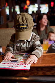 A child reviews the menu at Applebee's, which on Veterans Day will provide free Thank You meals to veterans and active duty military.