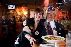 A team member and a veteran share a smile at Applebee's on Veterans Day, where veterans and active duty military receive a free Thank You meal.