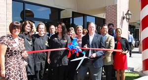 Roosters MGC franchise owner Steve Milam, center, is assisted by his team and Chamber members for the store's ribbon cutting.