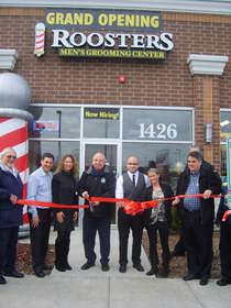 Taking part in the opening of Roosters Men's Grooming Center in Schaumburg are, from left to right, Village of Schaumburg Trustee Frank Kozak, Roosters' franchise owners Dave and Candace Laudadio, Schaumburg Mayor Al Larson, Roosters' stylists Jason Polanco and Kristen Louras, and Jeffrey Blair Hill of Primerica. 