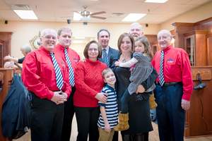 Roosters MGC franchise owners Maria and Michael Raduazzo, center, are pictured with their family and members of a local barbershop quartet for the store's grand opening in Norwalk. Photo courtesy of Chele Modica. 