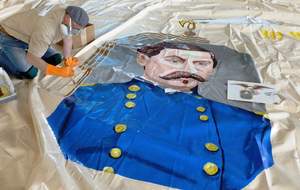 One side of the deflated Intrepid is hand-painted by illustrator Todd Price in May 2012.