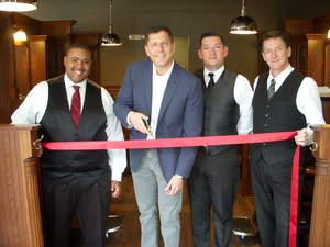 Preparing to cut the ribbon for the opening of Roosters Men's Grooming Center in Linden Square, is store owner John Santanella assisted by barbers, from left, Anthony Davis, Ryan Packer and Carl Cwiol.