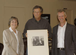 Janet Blake, curator of collections, Laguna Art Museum, and Malcolm Warner, executive director of Laguna Art Museum, presenting photographs by Paul Outerbridge to Festival of Arts Vice President Tom Lamb (pictured center)