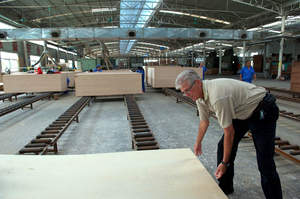 Rod Loe, VP Global Production for TigerPLY(TM), inspecting panels coming off the production line at a partner mill in China. With new technology in silviculture, Hybrid Eucalyptus plantations and world-class facilities, TigerPLY(TM) eCORE(TM) can be produced from sapling to plywood in just six years. (c) Lou Jones 2012.