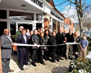 Mayor Dan Policastro of Mariemont, OH, in front at right, assists Dub Nelson, owner of Roosters Men's Grooming Center, with the store's official ribbon cutting.