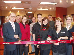 Participating in the Grand Re-Opening of Roosters Men's Grooming Center in Ballantyne are, front row l. to r., store owner Uli Seuster, Melissa Seuster, Suty Tran, Lisa  Dewispelare, Holly Wallace, Amy White and, back row, Pat Baldridge, Dave Baldridge, Ed Sedlacek and Chad Carpenter.