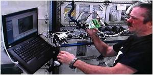 Canadian Astronaut Chris Hadfield performs a microscope survey of NanoRacks? microgravity protein crystal growth samples while aboard the International Space Station.