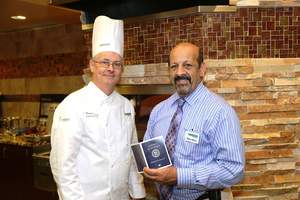 Executive Chef Pearse Tormey and Dining Manager Steve Berry review Oakwood Common's "Travel the World" passport.