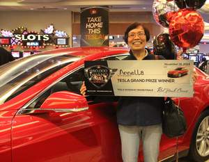 Arnella, from Sacramento, Calif., celebrates winning a brand new Tesla Model S at Red Hawk Casino.