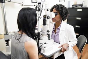 woman having eyes checked by eye doctor