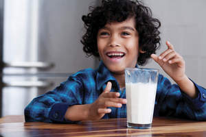 Child at the table with a glass of milk