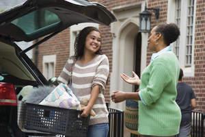 Mother and daughter talking while loading the car for college.