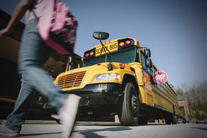 Child walking in front of stopped school bus.