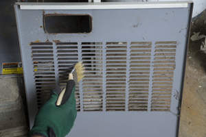 Cleaning a furnace filter cover.