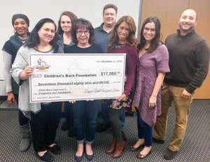 The Children's Burn Foundation team displays the donation received from Dryer Vent Wizard. CBF Executive Director Carol Horvitz is second from the left in the front row.