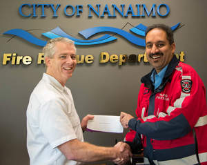 Canadian DVW franchisee Kelly Comeau in Nanaimo, British Columbia, presents an award of 500 dollars to Fire Prevention Officer Umesh Lal of the Nanaimo Fire Rescue Department, one of six fire safety programs in the U.S. and Canada to receive a DVW grant.