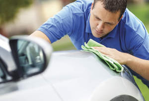 Man hand waxing a car.