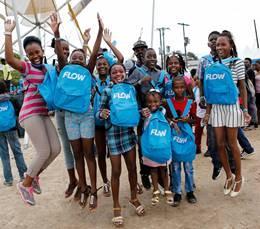 Students pose for the cameras with their brand new school bags received at FLOW Skool Aid 2016.