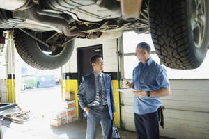 Two men talking about car repairs.