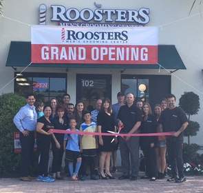 At center, Elaine and Bob Rourke, owners of Roosters Men's Grooming Center in Palm Beach Gardens, prepare to cut the ribbon for the store's official opening.