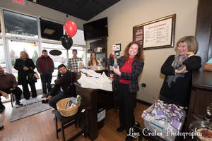 Susan Longworth shows her delight as she holds up the gift of rooster wind chimes from the Huntersville Chamber of Commerce