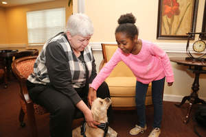 Geer Park student Madison Howell meets Beth Rager's dog Sugar during her tour of  Oakwood Common.