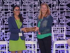 Katja Wald, executive director of the MIT Enterprise Forum of Cambridge, presents the Beantown Throwdown trophy to the 2017 winner, Wafaa Arbash, WorkAround founder and CEO